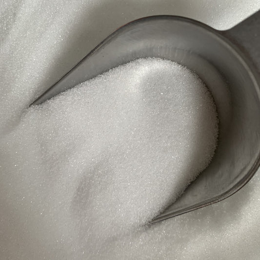 A scoop in a bowl of citric acid crystals