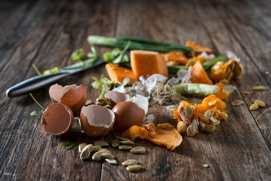 Wooden table containing a pile of food waste such as eggshells and pumpkin flesh